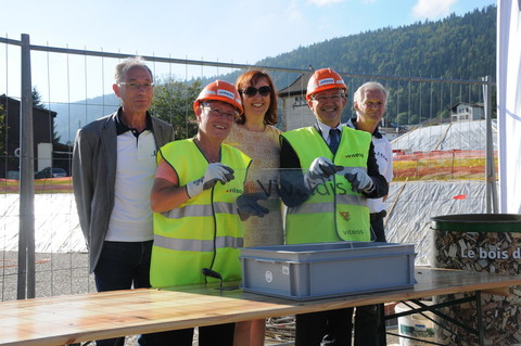 La pose de la première pierre du chauffage à bois, en compagnie de la directrice générale de Viteos Josette Frésard et du conseiller communal François Cuche.