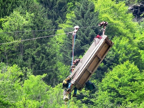 Femme secourue d'un téléphérique servant au transport de matériel