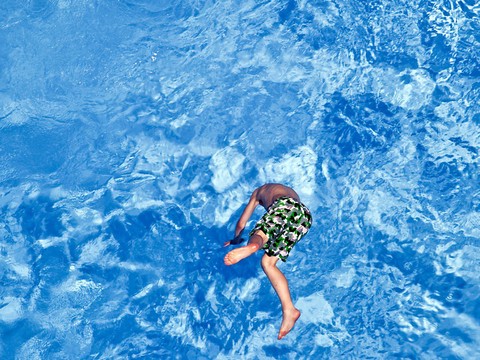 Il filme des enfants avec son stylo à la piscine