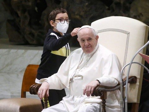 Un garçonnet s'assoit à droite du pape et veut sa calotte