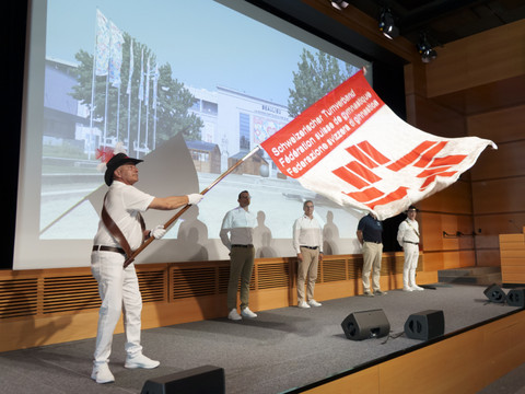 Lausanne 2025 reçoit la bannière de la FSG des mains d'Aarau 2019