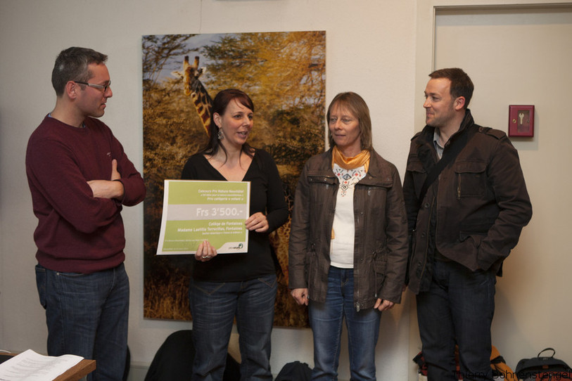 Président du jury de Pro Natura Neuchâtel, René Amstutz (à gauche) remet un prix à des enseignants du collège de Fontaines.