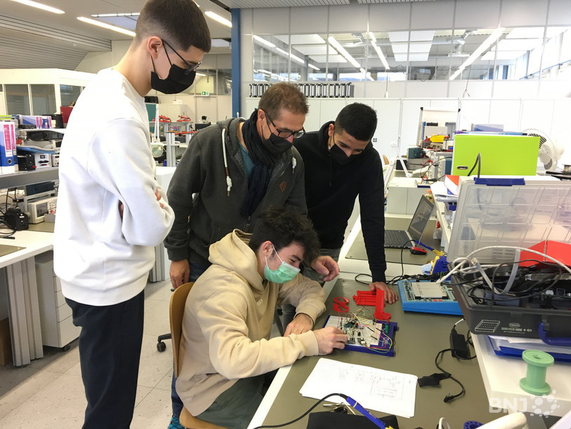 Diego, Alan, Samy et leur professeur René Grossmann jettent un oeil sur les composés électroniques de leur satellite.