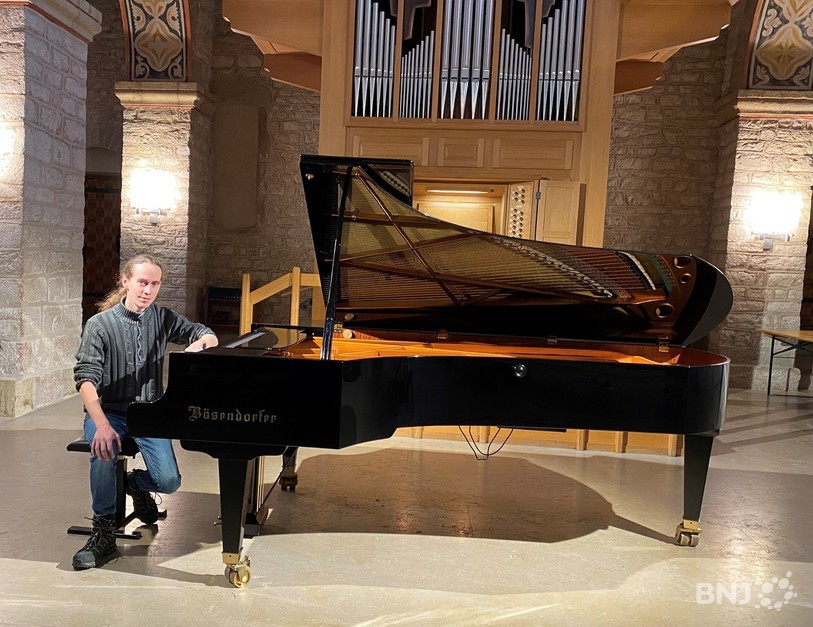 Johan Treichel pose au piano de la Collégiale de St-Imier.