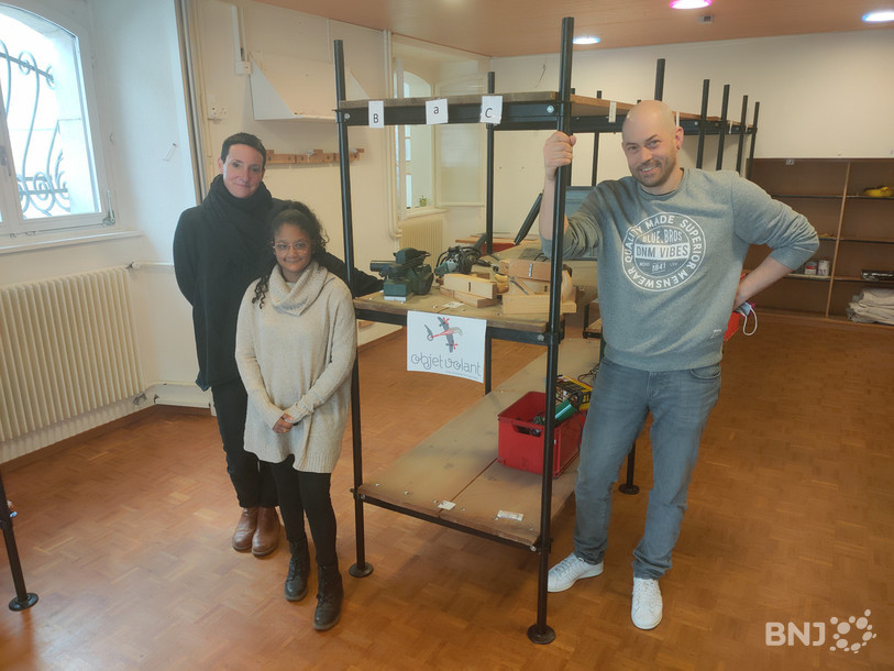Peggy Pagni et David Bassin entourent Zahra, l'une des jeunes qui participe à la mise en place de la bibliothèque d'objets.