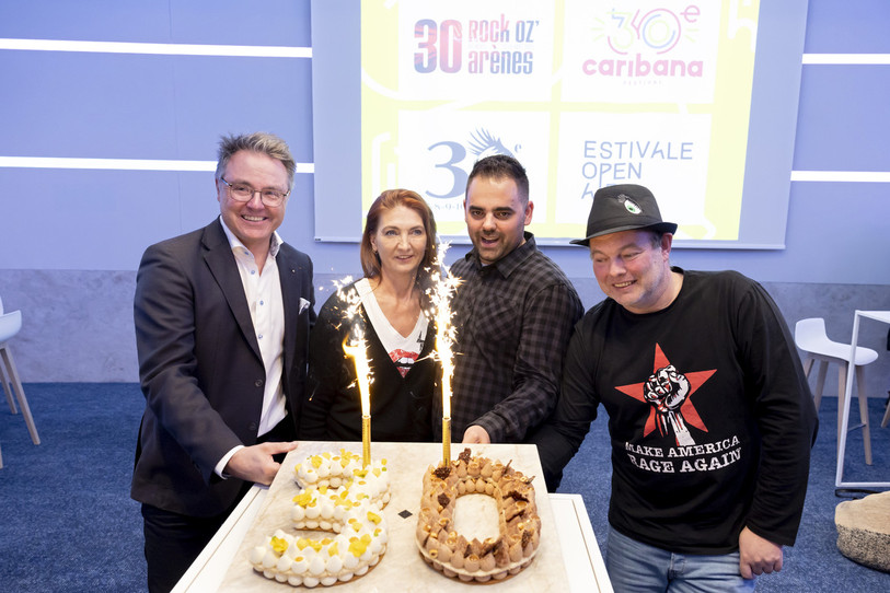 De gauche à droite : Tony Lerch, directeur du festival Caribana, Charlotte Carrel, directrice artistique du festival Rock Oz'Arenes, Nicolas Bally, directeur du festival Estivale Open Air, Gilles Pierre, directeur du festival Chant du Gros, posent avec un gâteau d'anniversaire pour célébrer les 30e éditions de leurs festivals respectifs, ce mercredi 16 mars 2022 à Crissier. (Photo : KEYSTONE / Salvatore Di Nolfi).