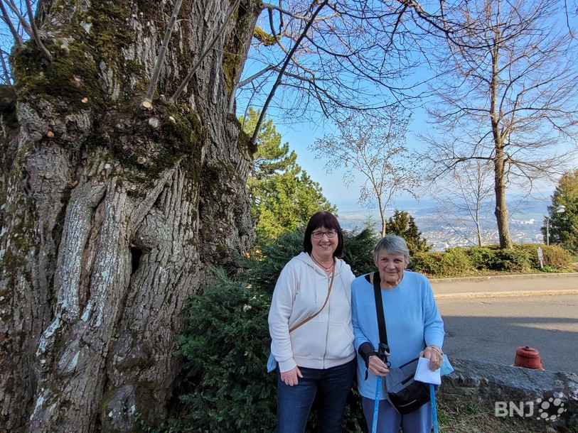 Gabrielle Stachel et Suzanne Gerber, deux habitantes d'Evilard de longue date, qui posent à côté du tilleul planté il y a plusieurs centaines d'années.