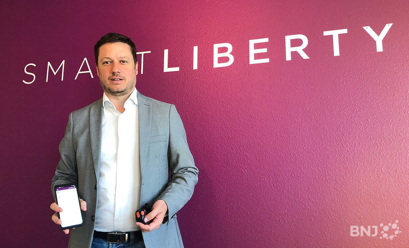 Tobias Britz avec un smartphone, qui regroupe toutes les fonctionnalités pour les utilisateurs des produits Smart Liberty.
