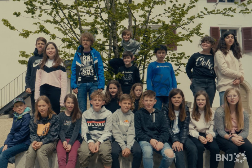Les élèves de 7H et 8H du cercle scolaire du Clos du Doubs chantent dans les rues de St-Ursanne. (photo : Un monde sans histoire/Sébastien Déboeuf)
