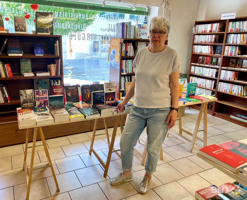 Micheline Huguelet pose à côté de la table dédiée aux romans policiers dans sa librairie de Moutier. 
