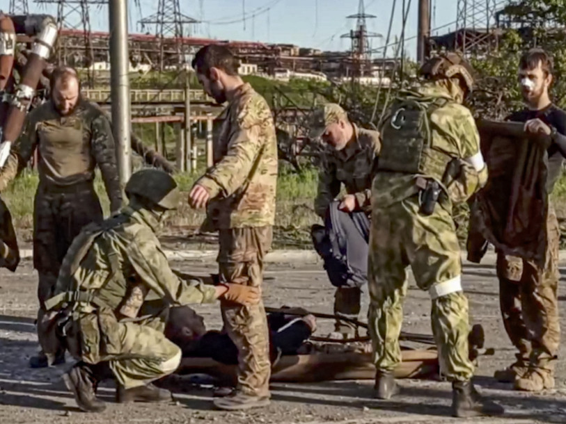Des soldats russes fouillent des soldats ukrainiens évacués d'Azovstal. (Photo : KEYSTONE / EPA / Russian defence ministry press service handout)