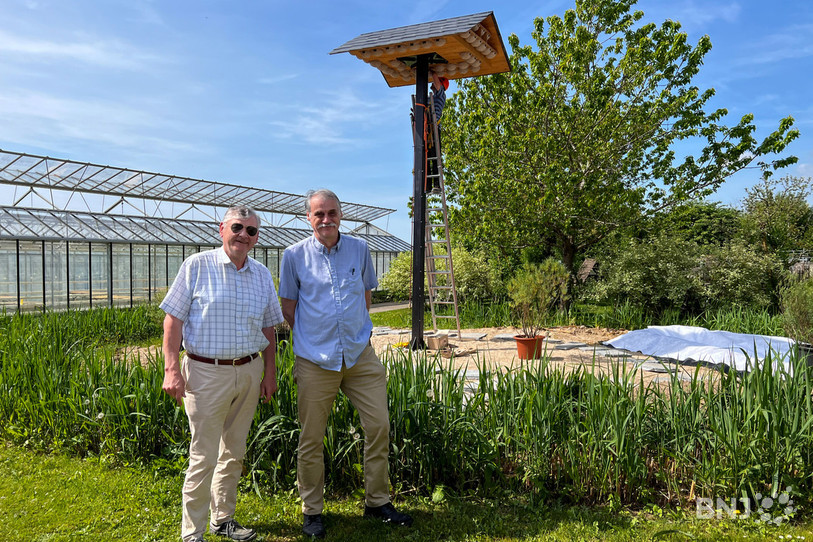 Daniel Henry, président de Pro Evologia, et Philippe Chopard, secrétaire du comité, posent à côté de la toute nouvelle tour à hirondelles du parc.