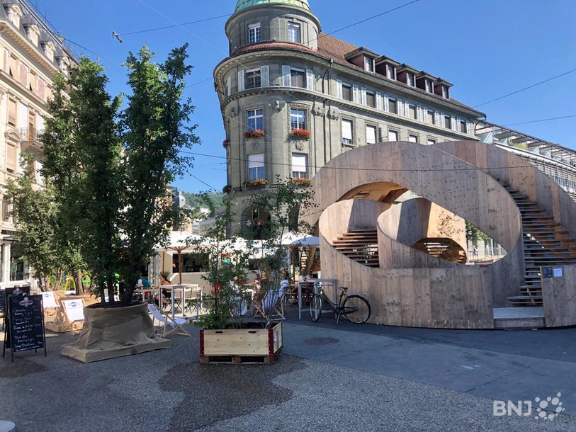 Le café « soleil » autour des arbres de « LabCity » et de sa sculpture en bois sur la place Centrale.