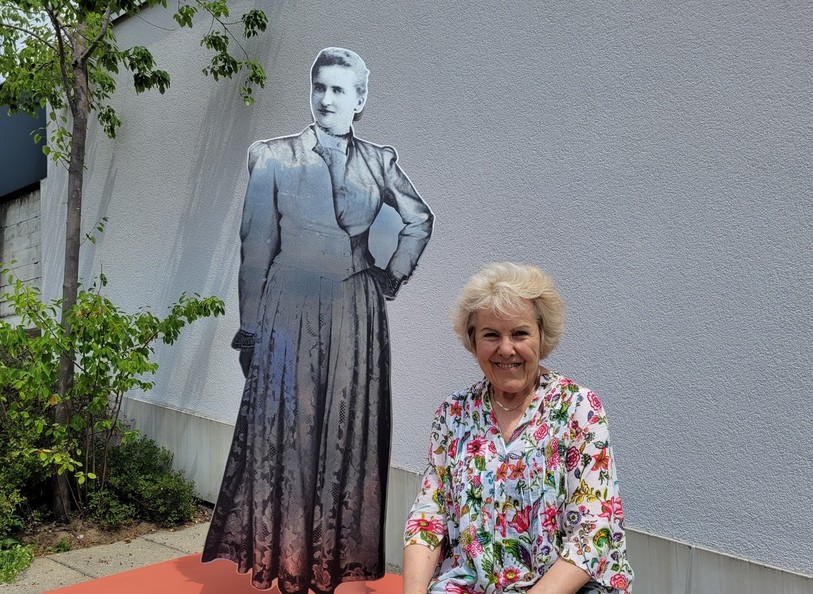 Janine Worpe, l'une des descendantes de la famille Gobat, qui pose devant la statue dédiée à Marguerite Gobat, à Tramelan.