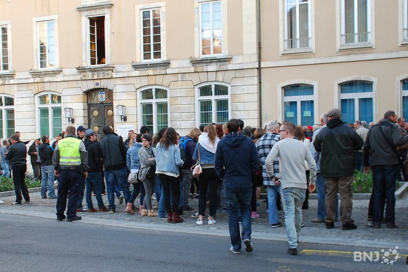 Des gens de dos devant un immeuble