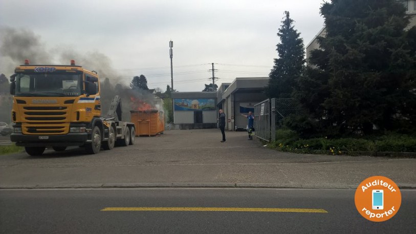 La benne a été déposée devant un entrepôt