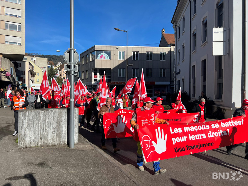Travailleurs et syndicalistes ont marché ensemble lundi à Delémont et dans plusieurs villes de Suisse romande pour défendre les conditions de travail du secteur de la construction.