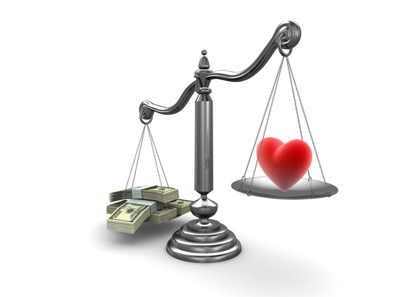 Balance avec un coeur d'un côté et des liasses de billets de l'autre