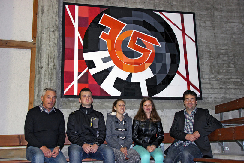 L’enseignant Georges Rossel (à gauche) et Florian Degoumois (à droite), président du comité du 75e, entourent une partie des élèves qui ont réalisé la fresque. Au centre Anaïs, l’initiatrice du projet (ldd)