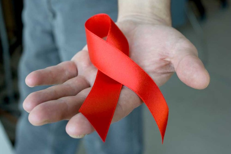Main tendue avec un ruban rouge