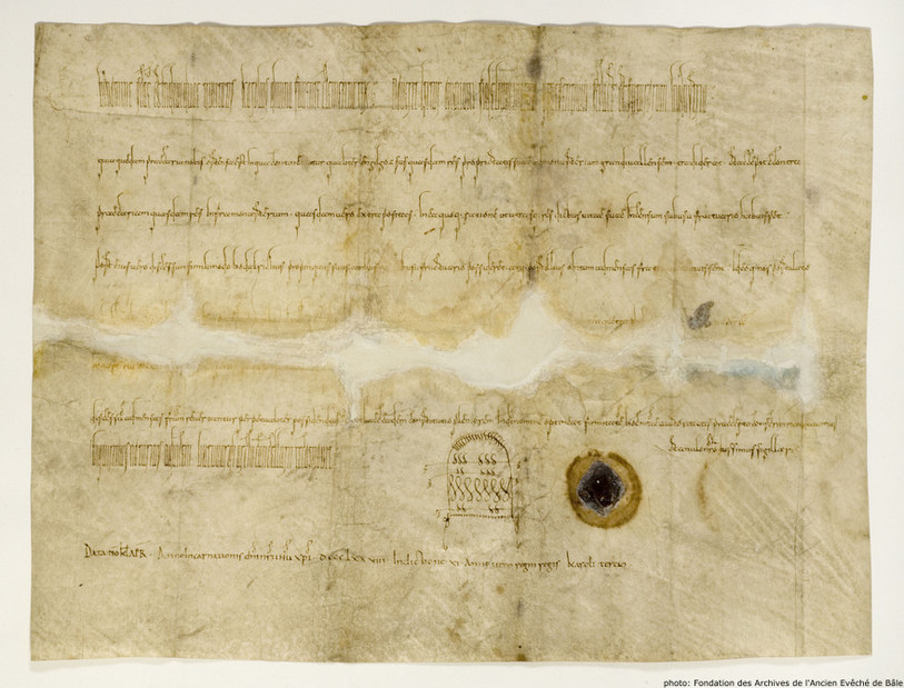 Ce document a été réalisé en 878. Il concerne le couvent de Moutier-Grandval. Le document est entreposé dans la Fondation des Archives de l'Anvien Evêché de Bâle.