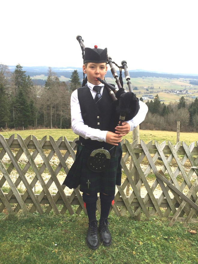 Enfant en kilt jouant de la cornemuse