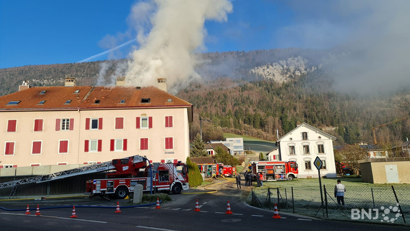 De la fumée s'échappe des combles du bâtiment.