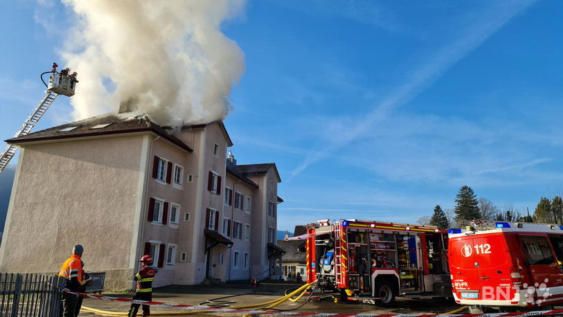 Beaucoup de fumée s'échappe depuis le toit du bâtiment.