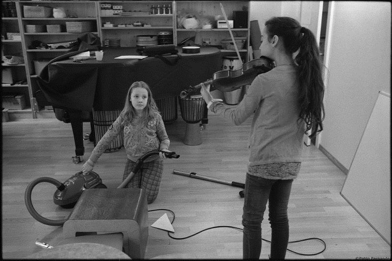 Une jeune violoniste et une autre avec un aspirateur