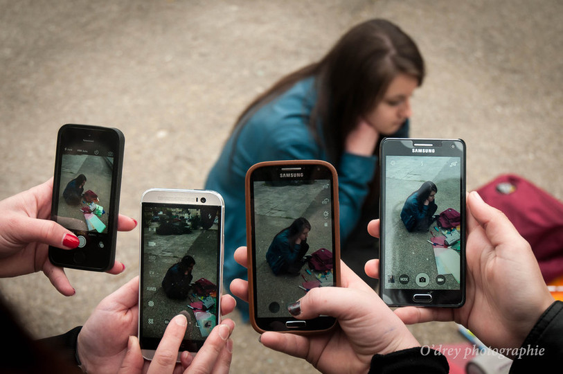 Jeunes filles qui filment une camarade à terre