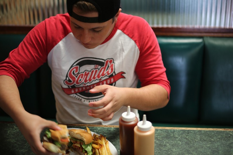 Adolescent qui mange un burger