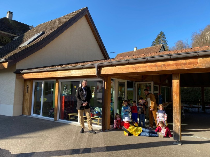 Le maire de Soyhières prend la pose devant la garderie du village, en compagnie des enfants. Il a tenu à saluer l’importance de ce site pour les enfants de Soyhières et pour ceux du Haut Plateau. (Photo : Christian Zuber).