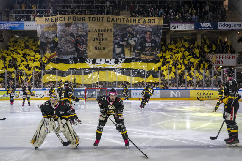 Le splendide tifos déployé par les supporters du HC Ajoie en hommage à leur capitaine Jordane Hauert, qu’on aperçoit déjà très concentré aux côtés du gardien Tim Wolf. (photo : KEYSTONE/Georgios Kefalas)