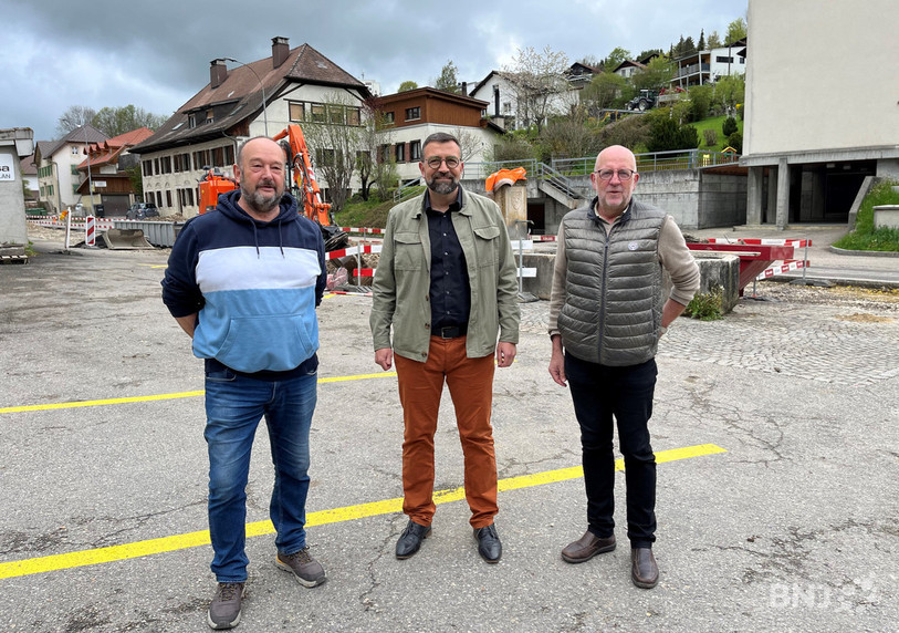 André Ducommun (conseiller municipal et vice-président de TEI SA), Hervé Gullotti (maire et président de TEI SA) et François Roquier (chef de projet) posent devant le premier chantier lié au chauffage à distance.