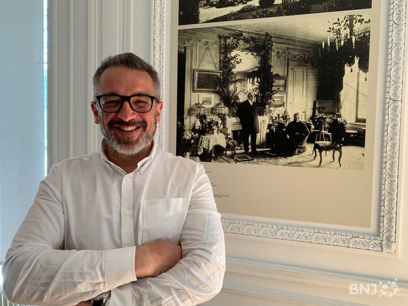 Le conservateur du musée d'histoire Francesco Garufo pose dans le salon de la villa Sandoz devant une photo représentant ses derniers habitants. 
