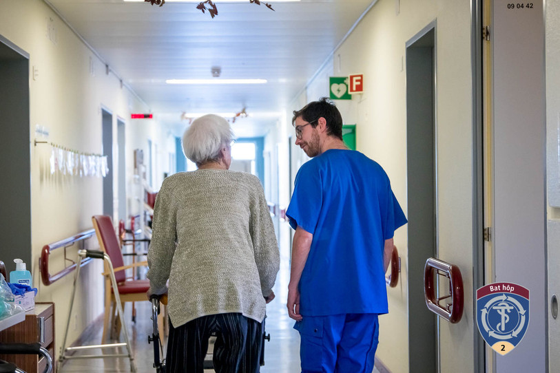 Un soldat du Bataillon hôpital 2 effectuant son cours de répétition en 2019, accompagnant une patiente dans des exercices de mobilité. (Photo : Hôpital du Jura)