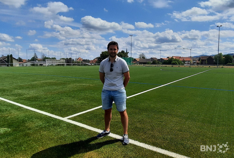 Mathieu Cerf, conseiller communal en charge des sports à Courgenay, pose devant la pelouse synthétique de son village.