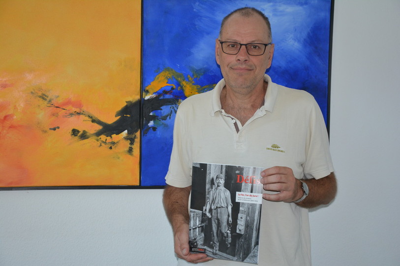 Le rédacteur responsable de « Défis » Didier Walzer présente fièrement le 17e numéro de sa revue, consacré à l'histoire du minerai de fer à Delémont. 