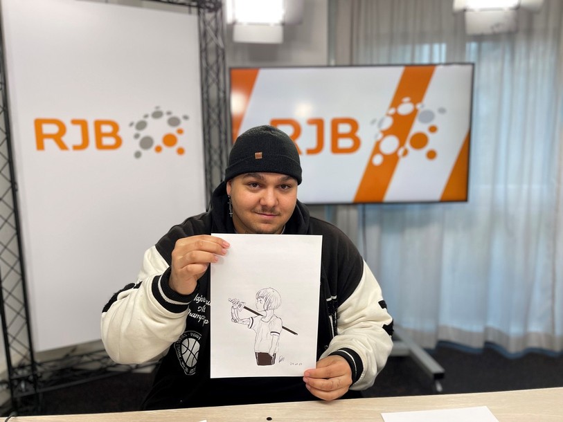 Roméo Jovanovic pose avec l’un de ses dessins à retrouver à Moutier.