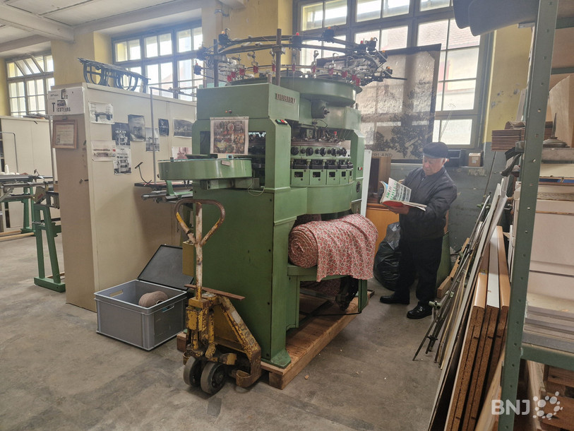 Luigi, ancien employé de Dubied, à côté de la machine à tricoter circulaire,