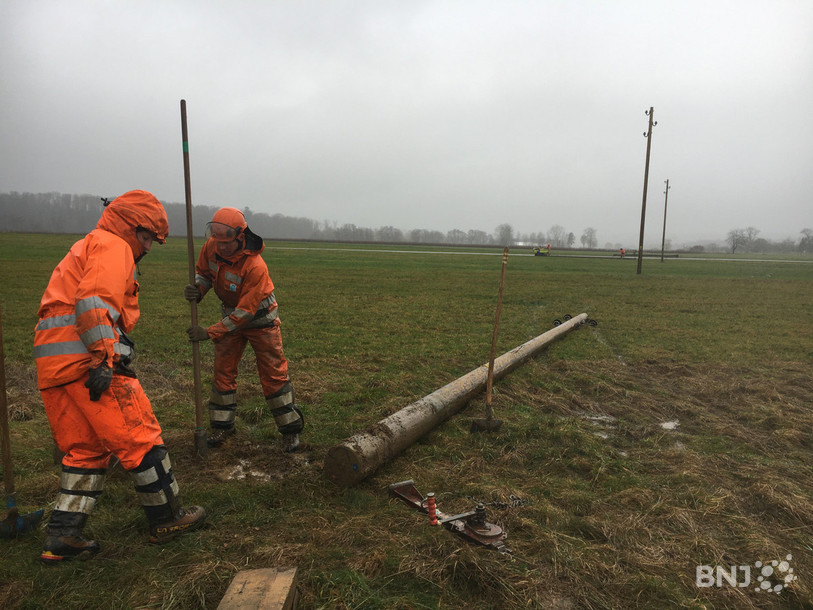 Des monteurs de ligne mettent en bas les poteaux devenus inutiles entre Miécourt et Charmoille.