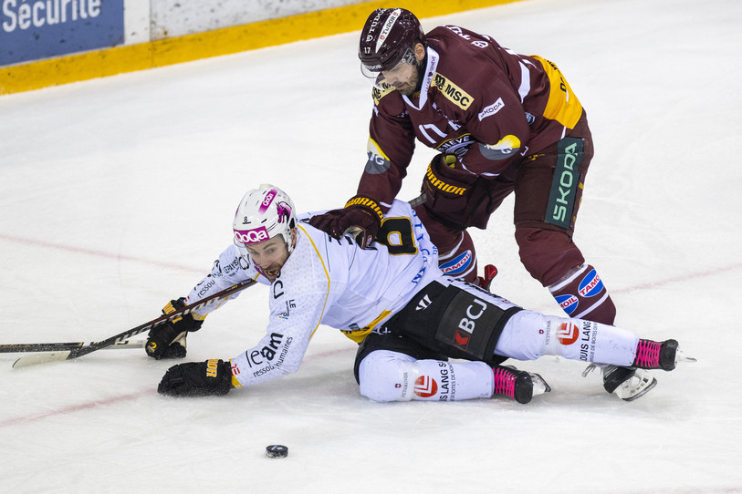 Philip-Michaël Devos (au sol) et le HC Ajoie n'ont pas su maîtriser le puck samedi soir à Genève (photo : KEYSTONE/Martial Trezzini).