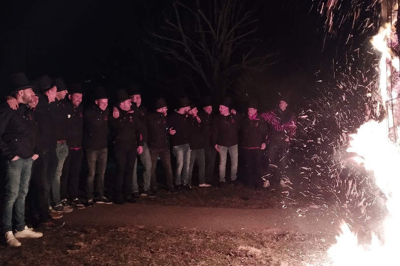 Les 15 membres du comité du Carnaval des Franches-Montagnes face au bonhomme hiver en feu.