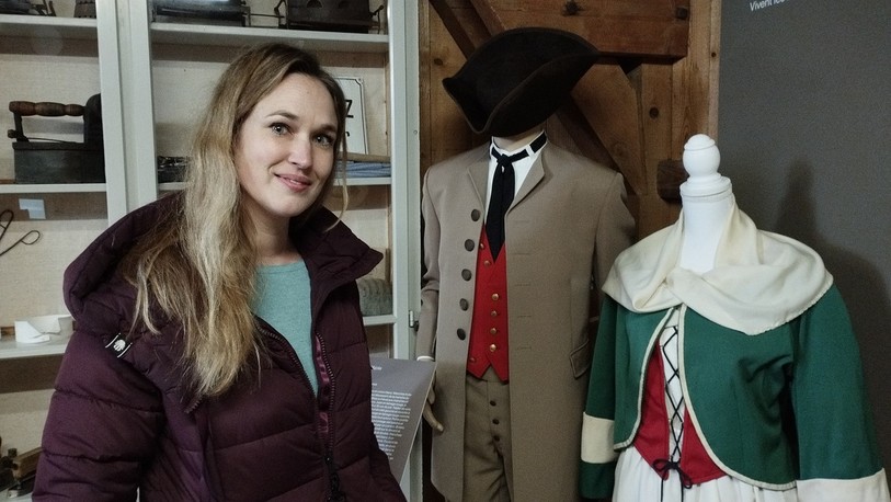 Nathalie Zürcher, conservatrice au Musée de la vie jurassienne, devant deux costumes des Patoisants d'Ajoie.