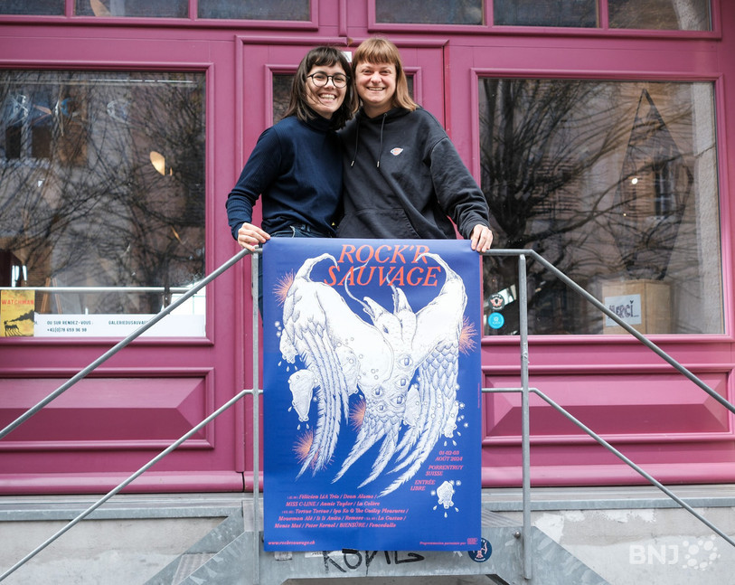 Justine Bonvallat (à gauche) et Tiffany Meyer, respectivement présidente et membre du comité du Rock'R Sauvage posent avec l'affiche de l'édition 2024 du festival.