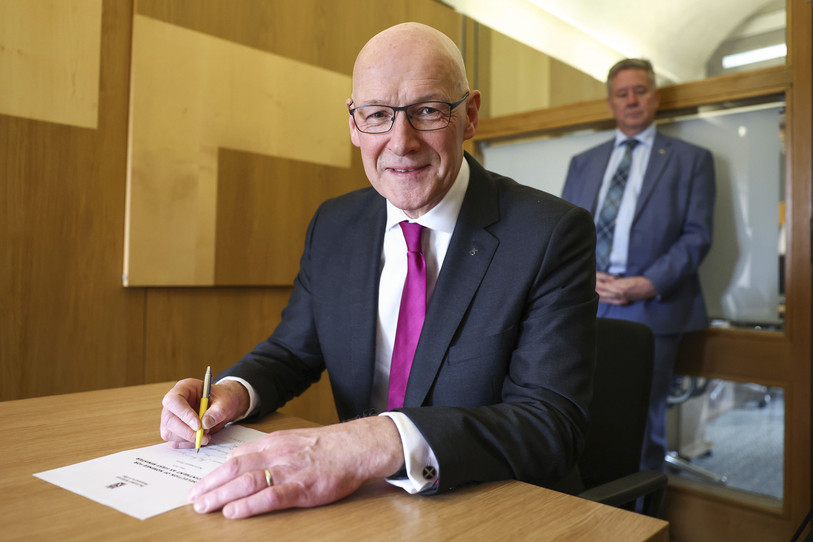 Le nouveau chef du Parti national écossais, John Swinney, signe sa lettre de nomination au poste de Premier ministre au Parlement écossais à Édimbourg, le mardi 7 mai 2024. (Photo ; AP/Jeff J Mitchell)