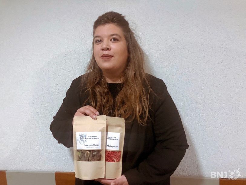 Aline Blaser tient dans ses mains deux de ses produits : des champignons et du poivre rouge.