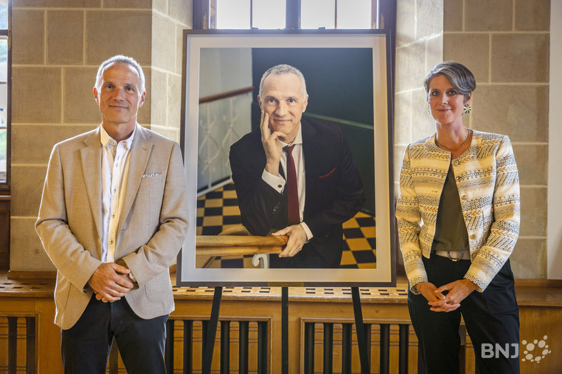 Laurent Kurth et la photographe Aline Henchoz pose avec le tableau de l'ex-ministre. (Photo : Chancellerie)