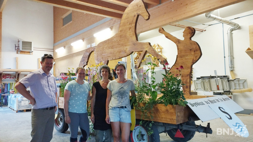 Marco Chételat, Elena Domon, Margueritte Clémençon et Kristina Buschwalder devant le char en cours de décoration avec des fleurs fournies par une fleuriste taignonne.