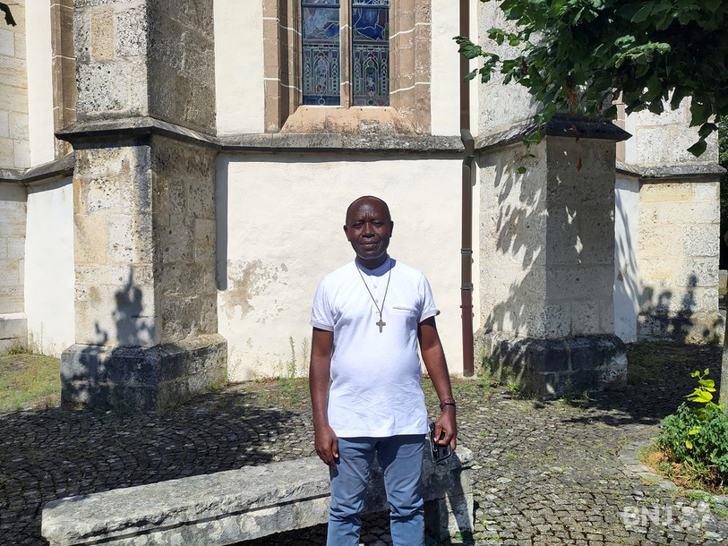 L'abbé Kisito pose devant l'église St-Pierre, à Porrentruy, lui qui officiera dans l'espace pastoral Ajoie - Clos-du-Doubs.
